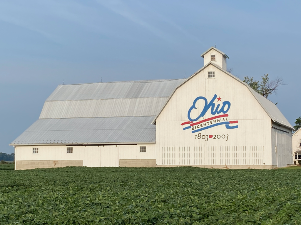 White barn in Ottawa County, Ohio, showing the Ohio Bicentennial (1803-2003) logo. Soybean field foreground.